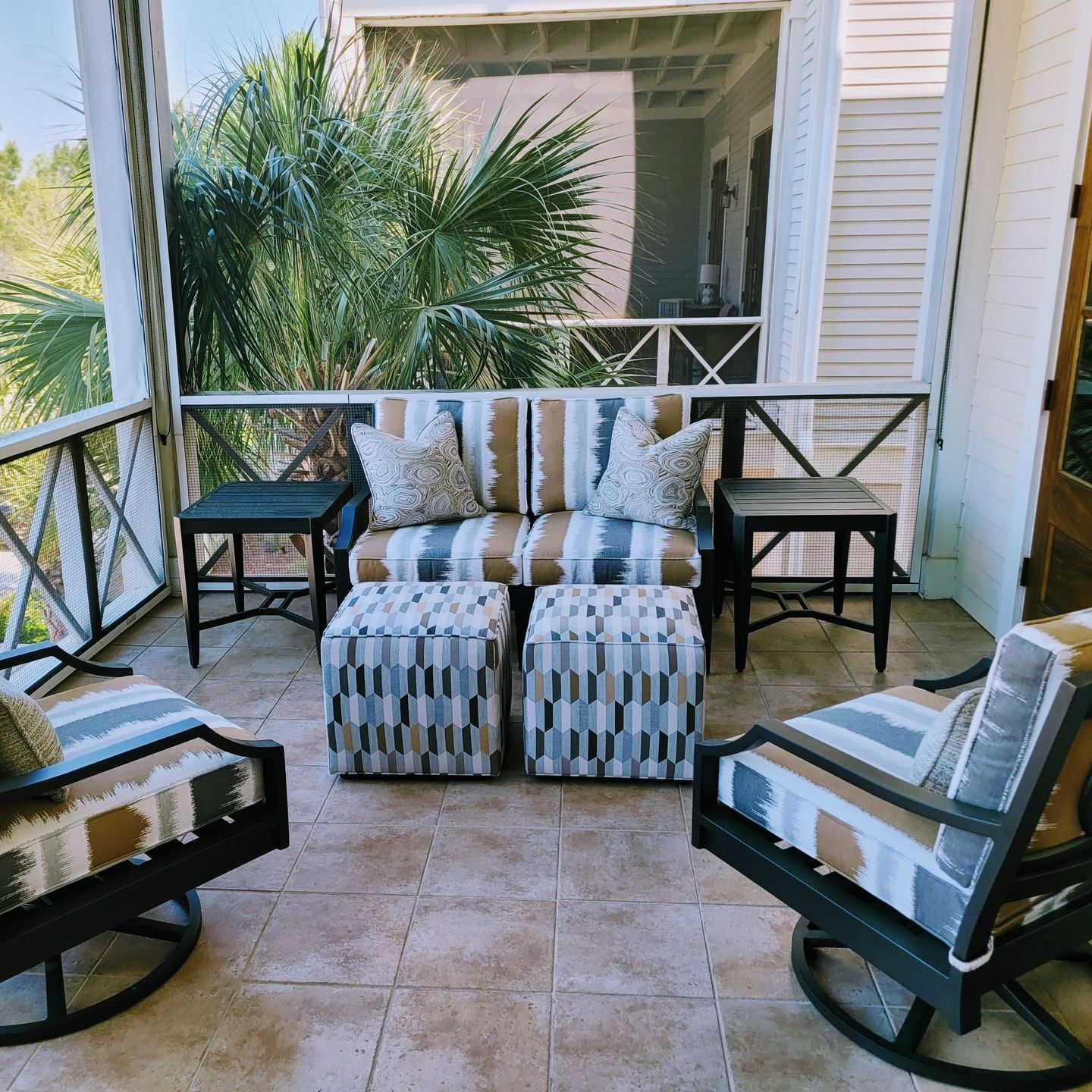 A screened in porch with a couch and chairs