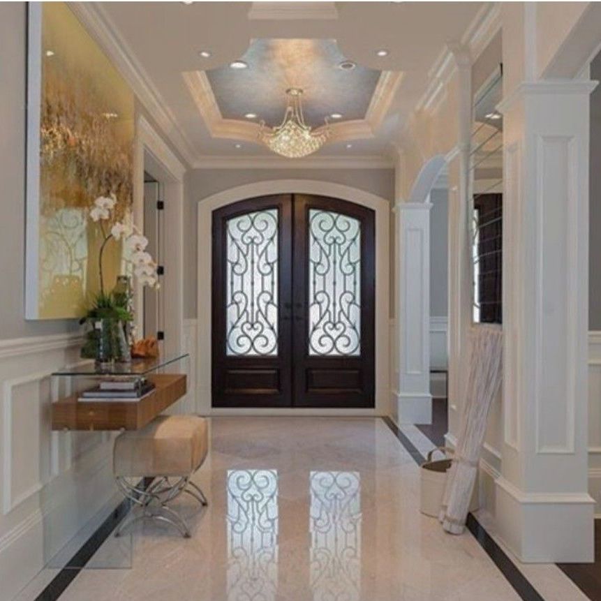 A hallway with a glass door and a chandelier