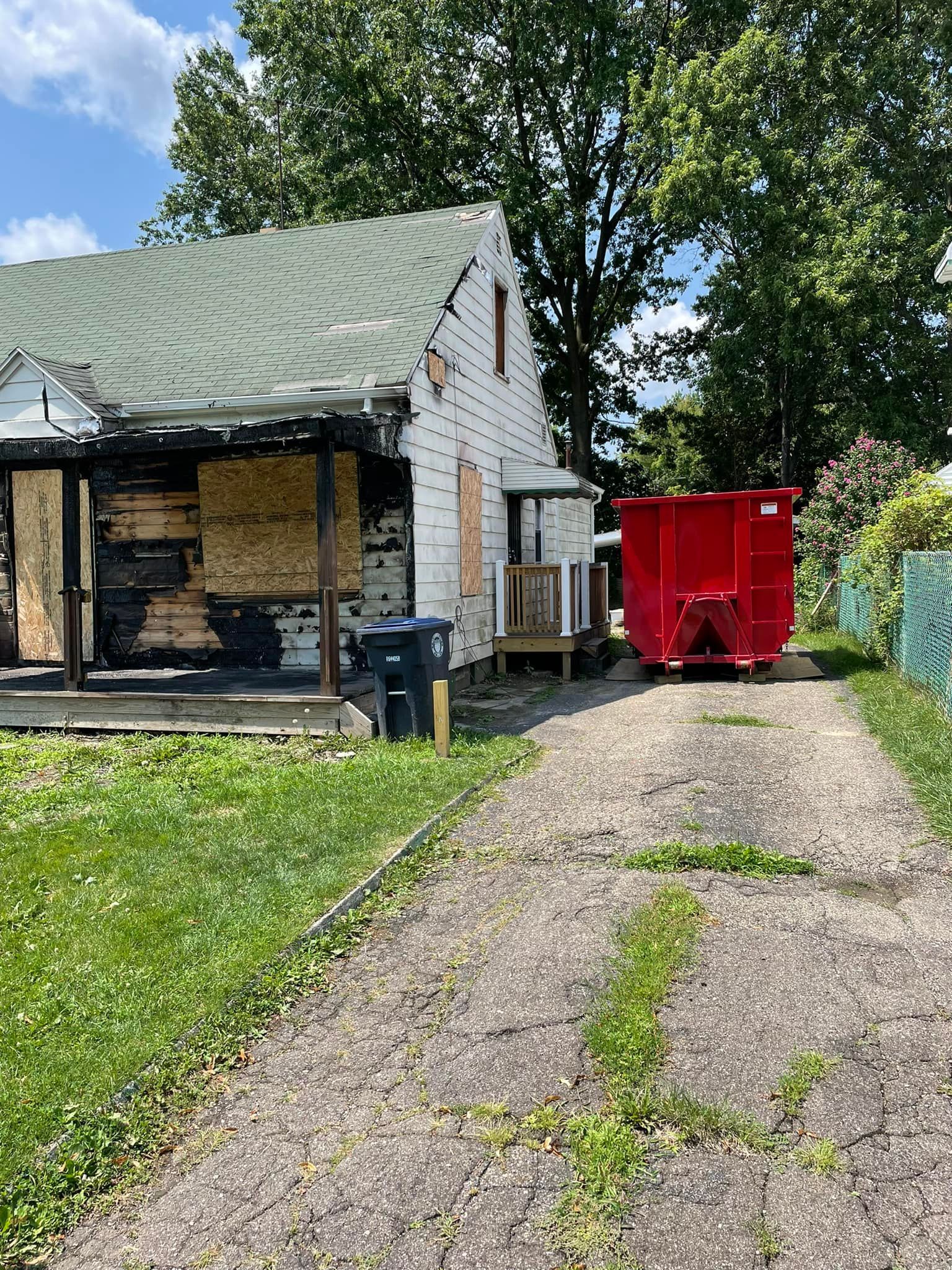 a red dumpster is parked in front of a house .