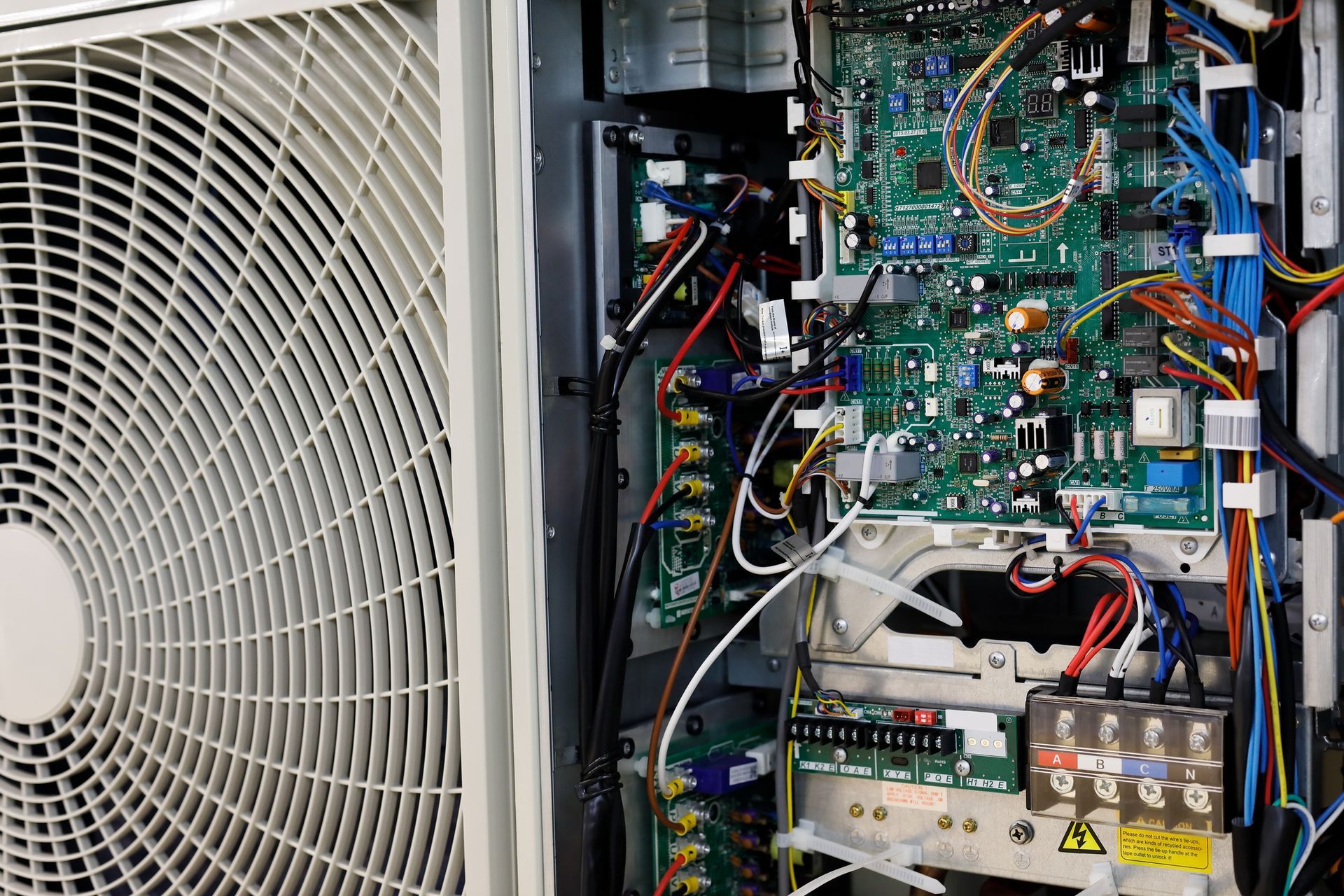 The inside of an air conditioner with a fan and a motherboard.