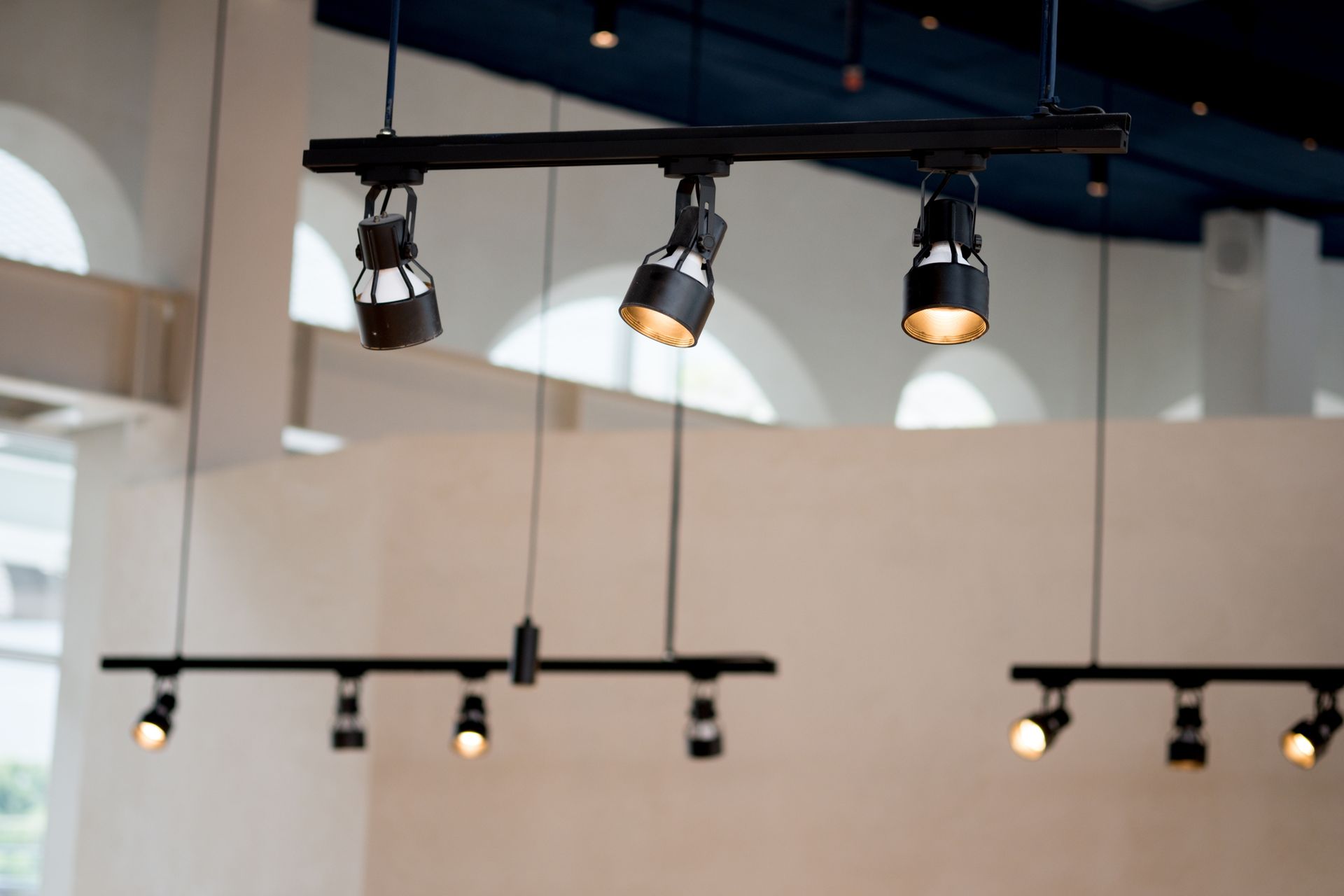 A row of spotlights hanging from the ceiling of a room.