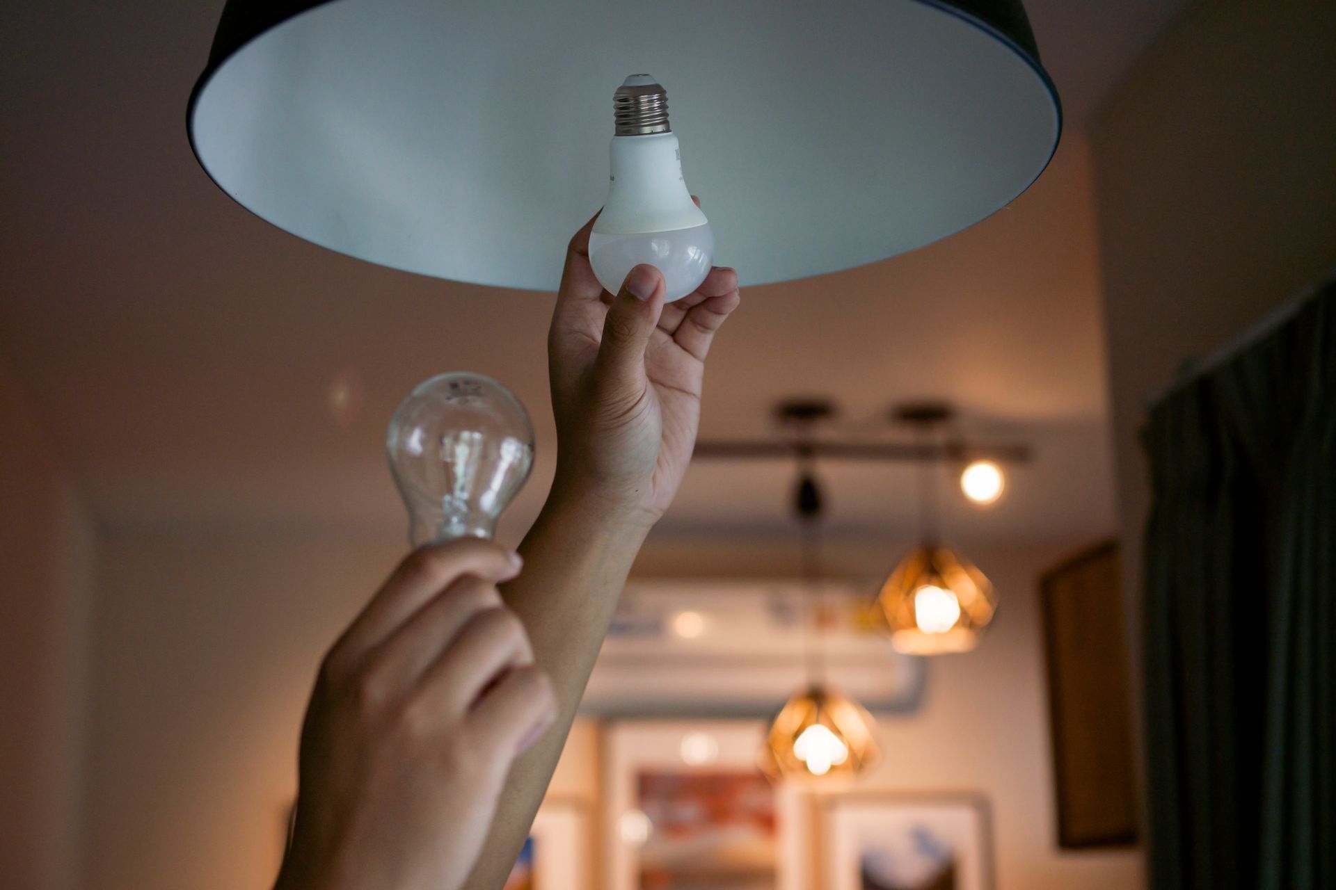 A person is changing a light bulb in a lamp.