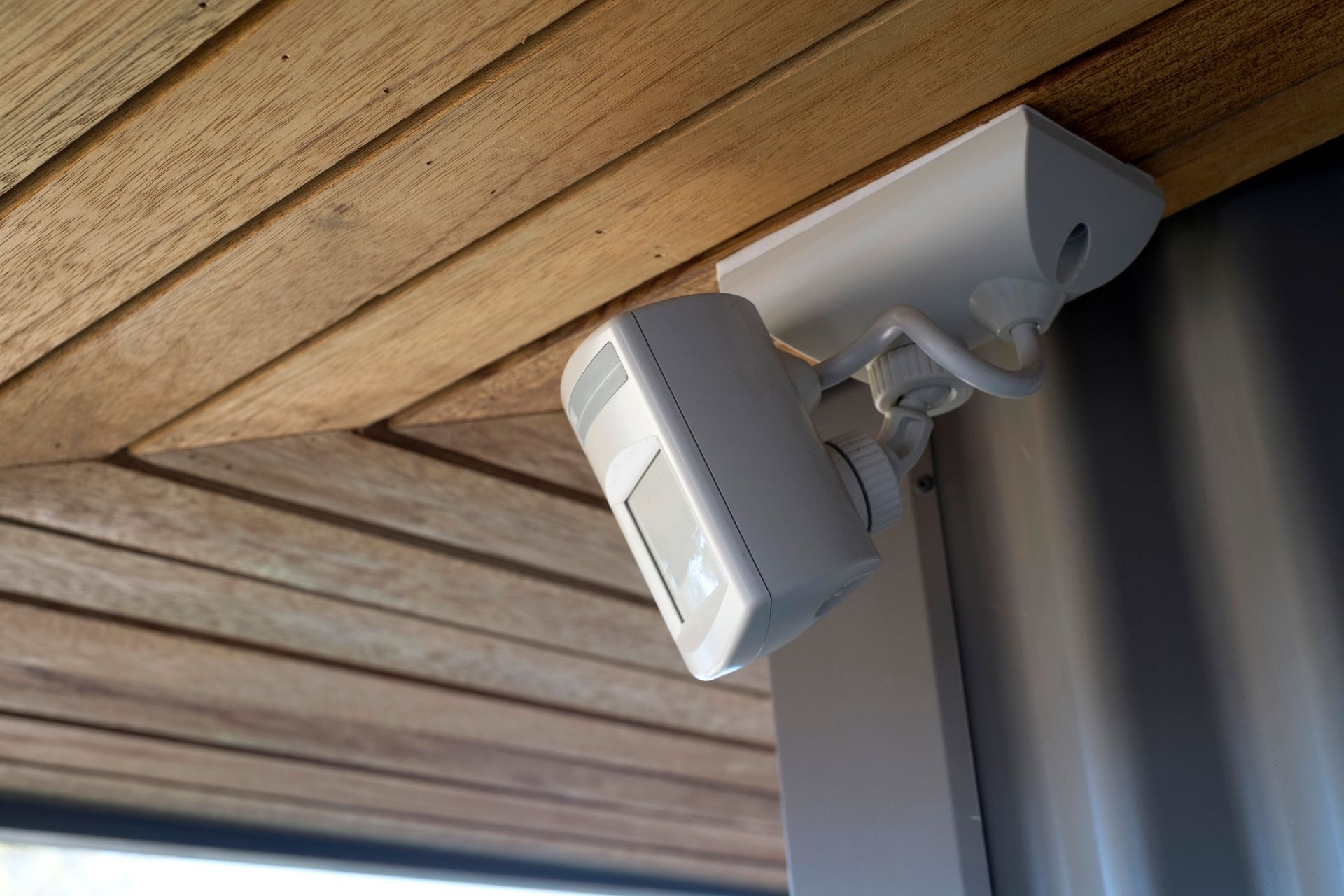 A security camera is mounted to the side of a building.