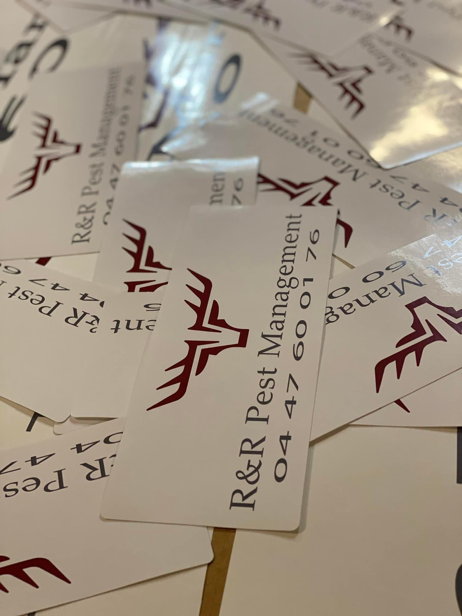 A Pile of Business Cards for R & R Pest Management — Global Signage In Ingham, QLD