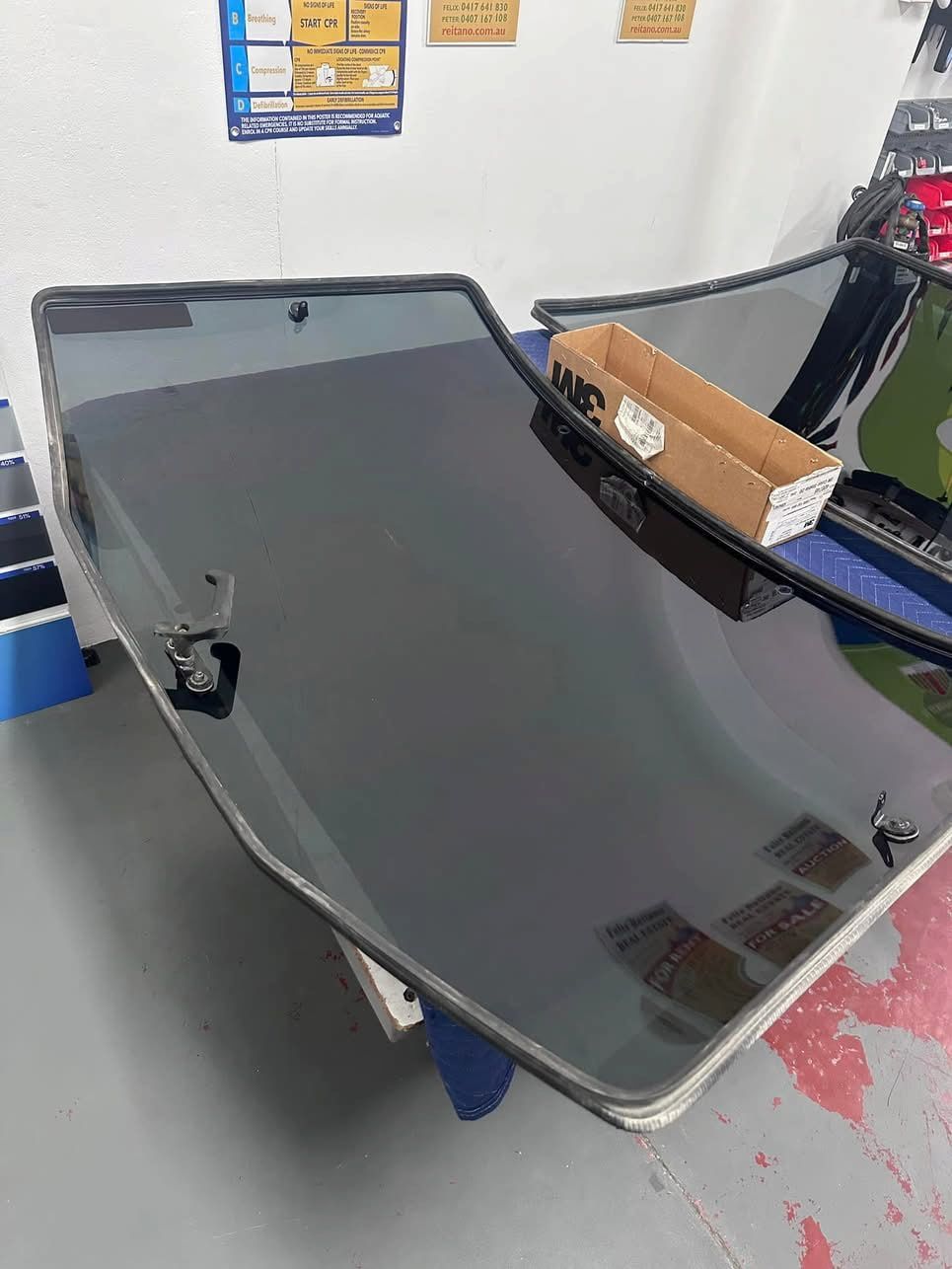 A Car Windshield is Sitting on Top of a Table in a Garage — Global Signage In Ingham, QLD