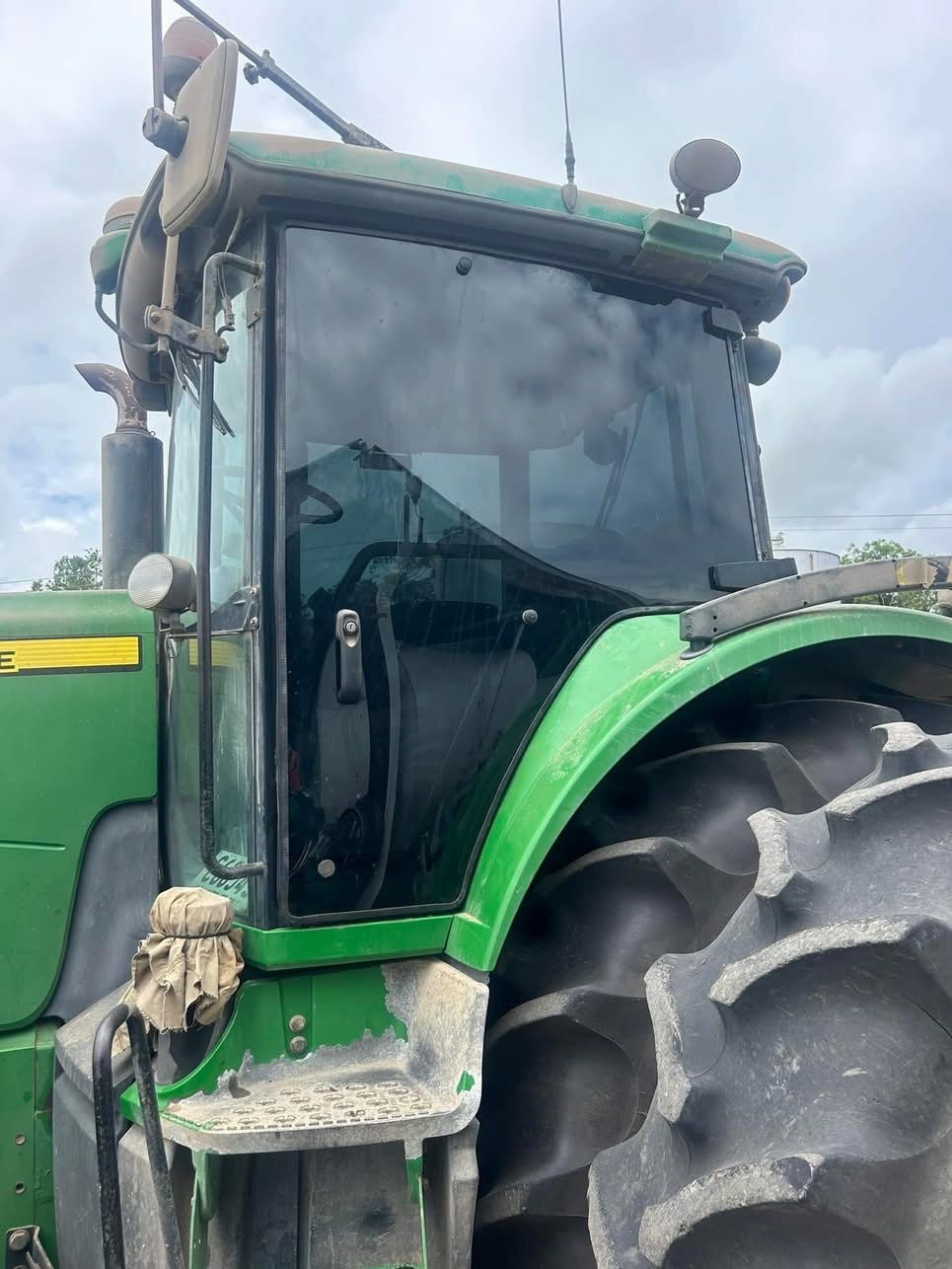 A Green John Deere Tractor is Parked in the Dirt — Global Signage In Ingham, QLD
