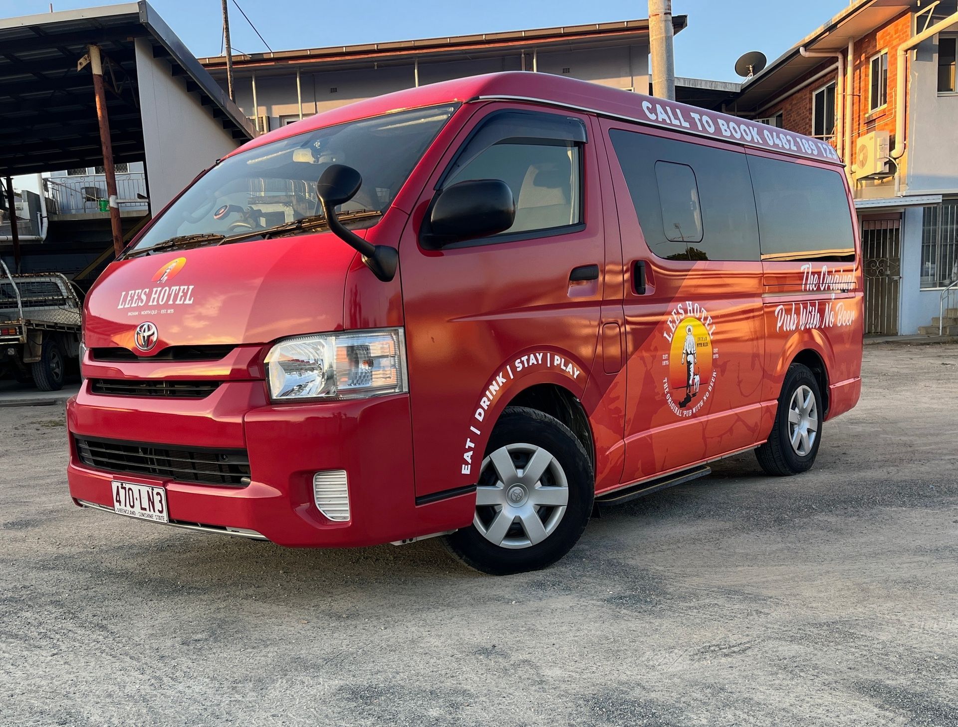 A white and blue bus is parked in a warehouse — Global Signage In Ingham, QLD