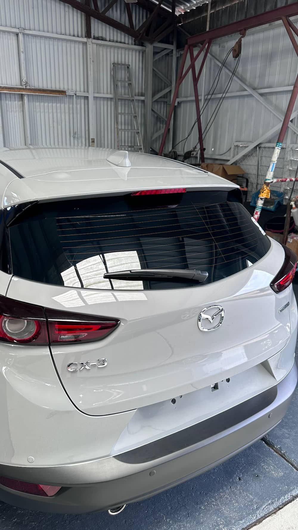 The Back of a White Car is Parked in a Garage — Global Signage In Ingham, QLD