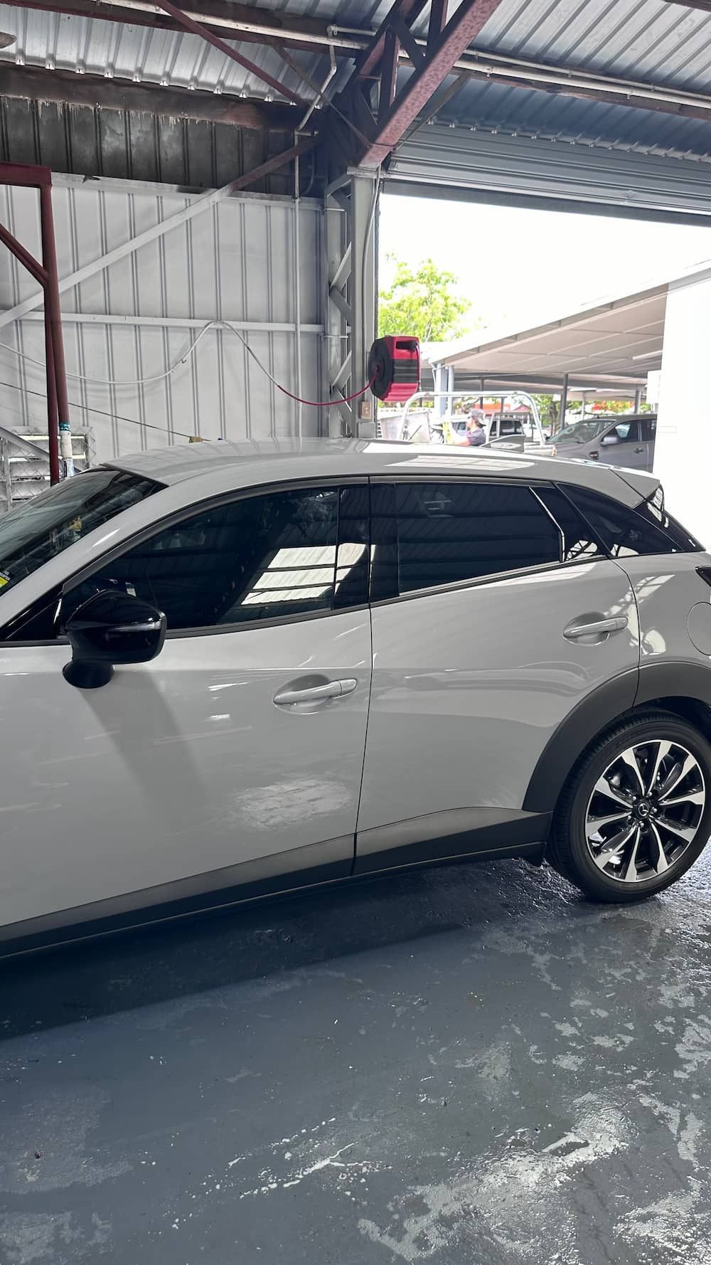 A White Car is Parked in a Garage With the Door Open — Global Signage In Ingham, QLD