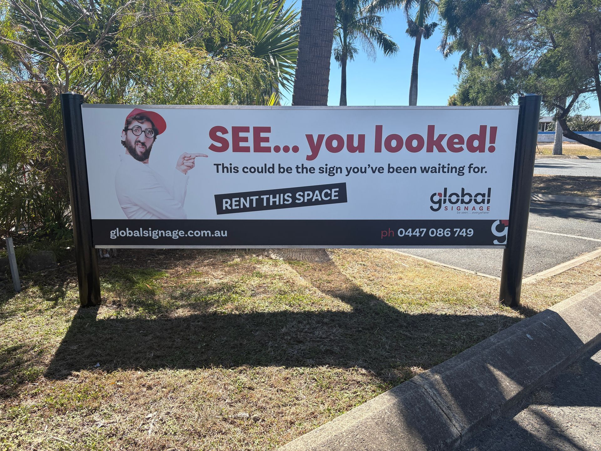 A Handicapped Parking Sign is Sitting in Front of a Tree — Global Signage In Ingham, QLD