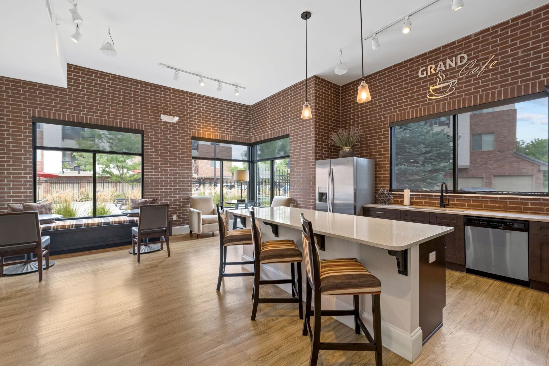 Brick-walled community lounge with a large island kitchen and seating.
