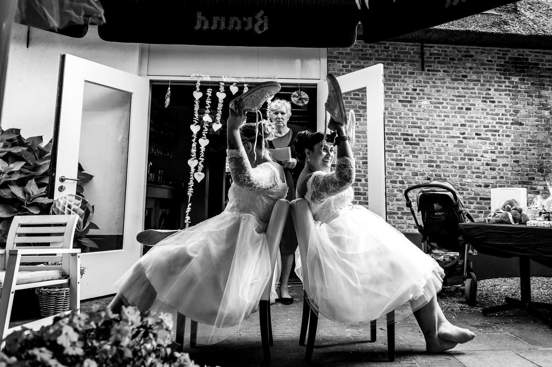 Twee vrouwen in trouwjurken doen spel op hun bruiloft