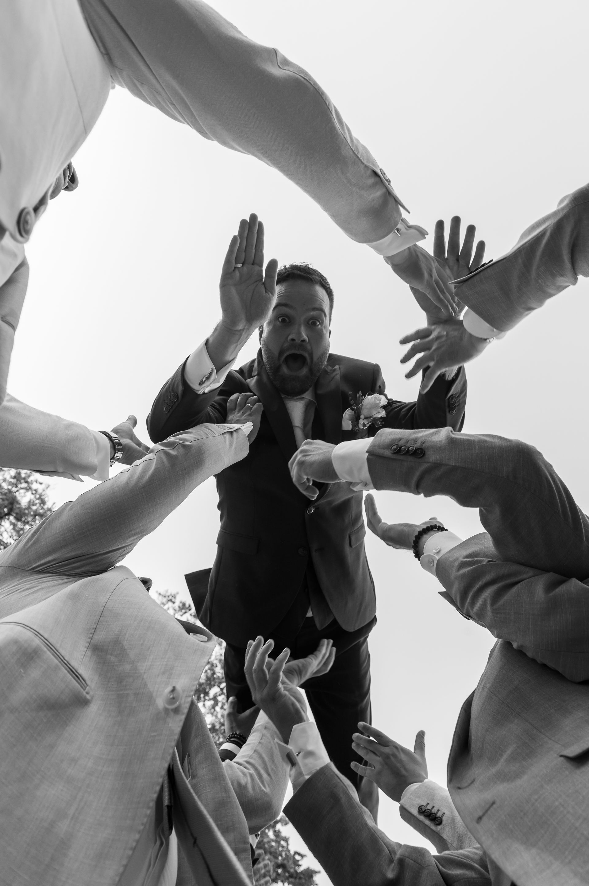 Bruidego word in de lucht gegooid door vrienden.