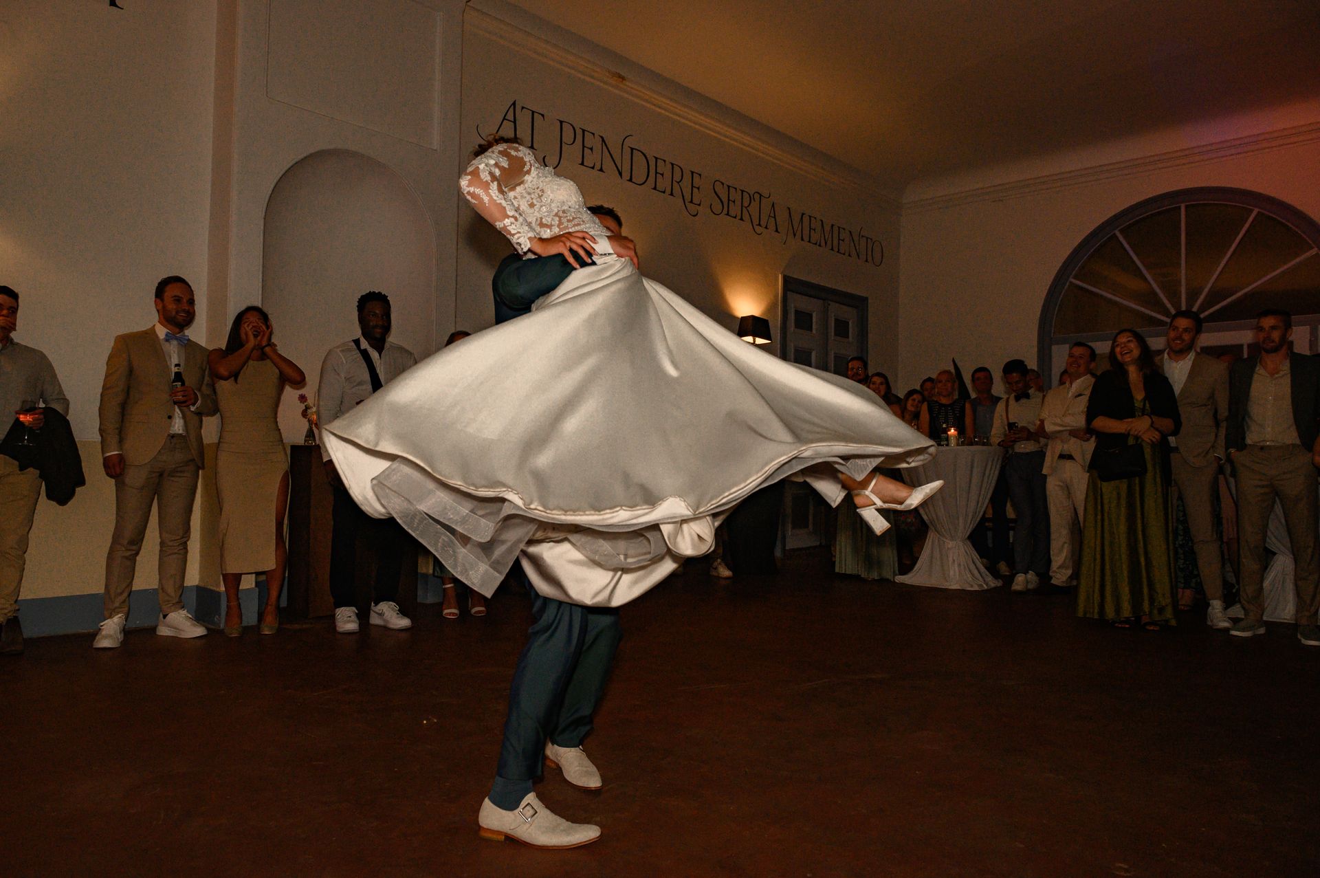 Een bruid en bruidegom dansen voor een publiek op een huwelijksreceptie.