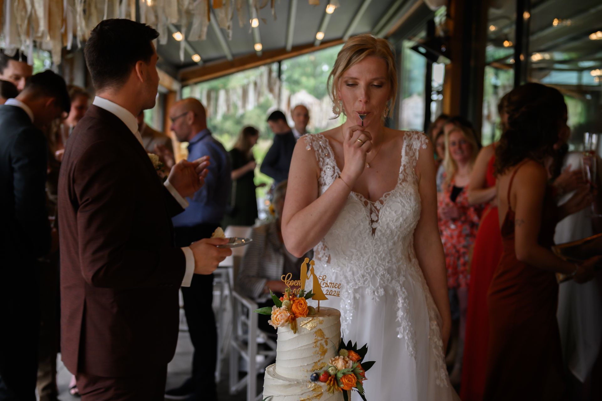 Een bruid en bruidegom snijden hun bruidstaart aan op een receptie.