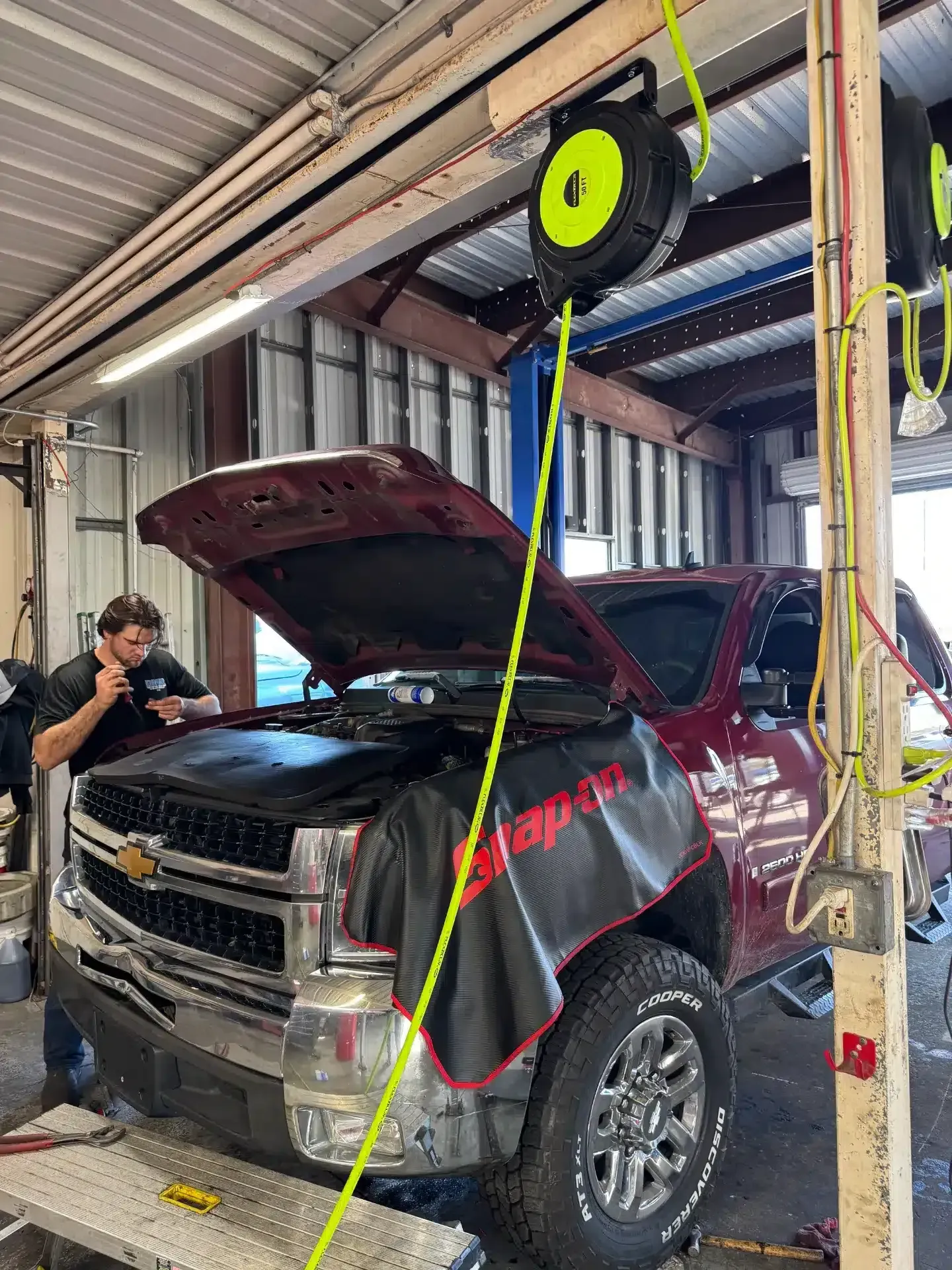 Technician on Work with Red Truck Hood Up | DMR Diesel Repair, Inc