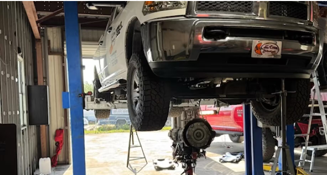 White truck raised up in Garage | DMR Diesel Repair, Inc