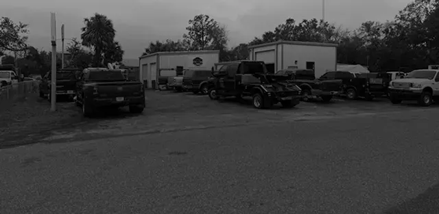 Black and white vehicles parked outside | DMR Diesel Repair, Inc