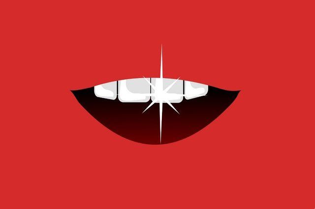 A close up of a person 's mouth with white teeth on a red background.