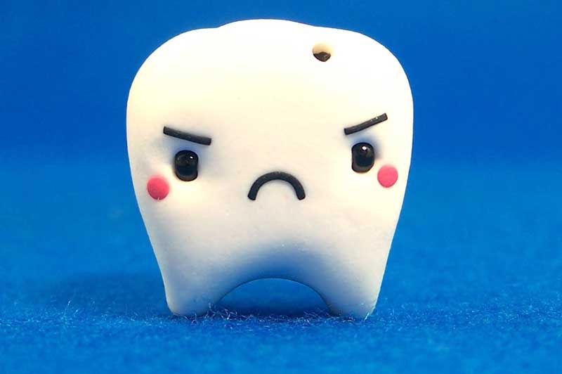 A white tooth with a sad face on it