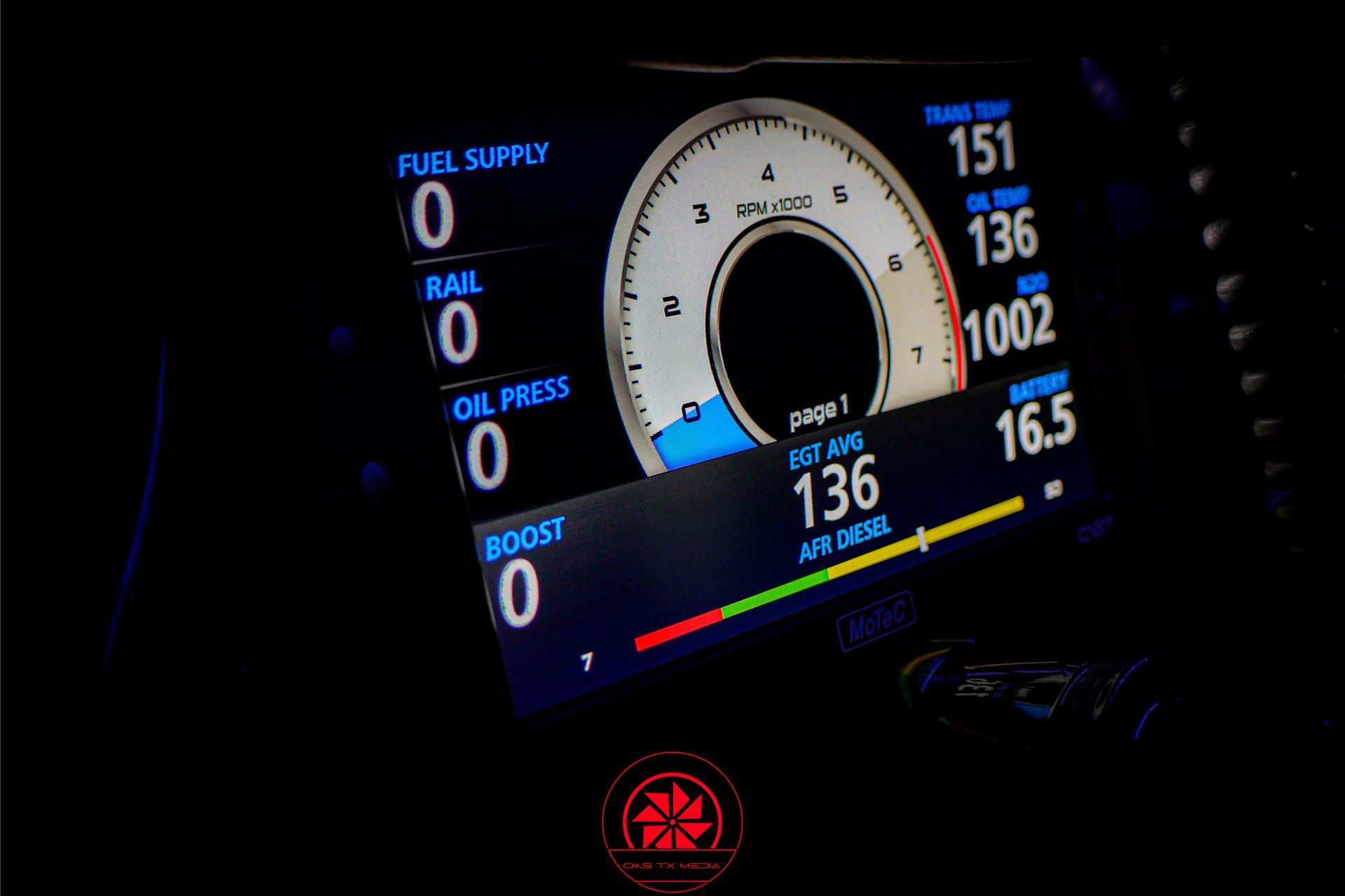 Car dashboard digital gauge cluster at night, showing 136 mph and performance readouts on a dark display