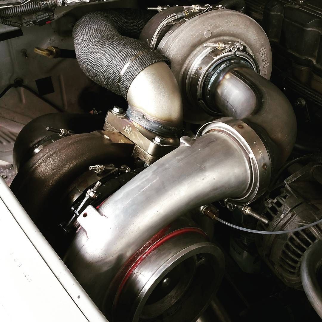 Industrial engine components with silver turbochargers and metal piping inside a machine compartment