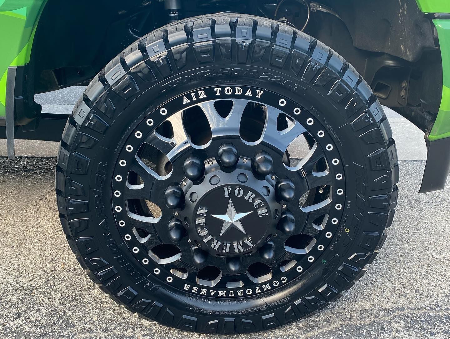 Close-up of a black off-road truck wheel with star-pattern rim and rugged tire tread