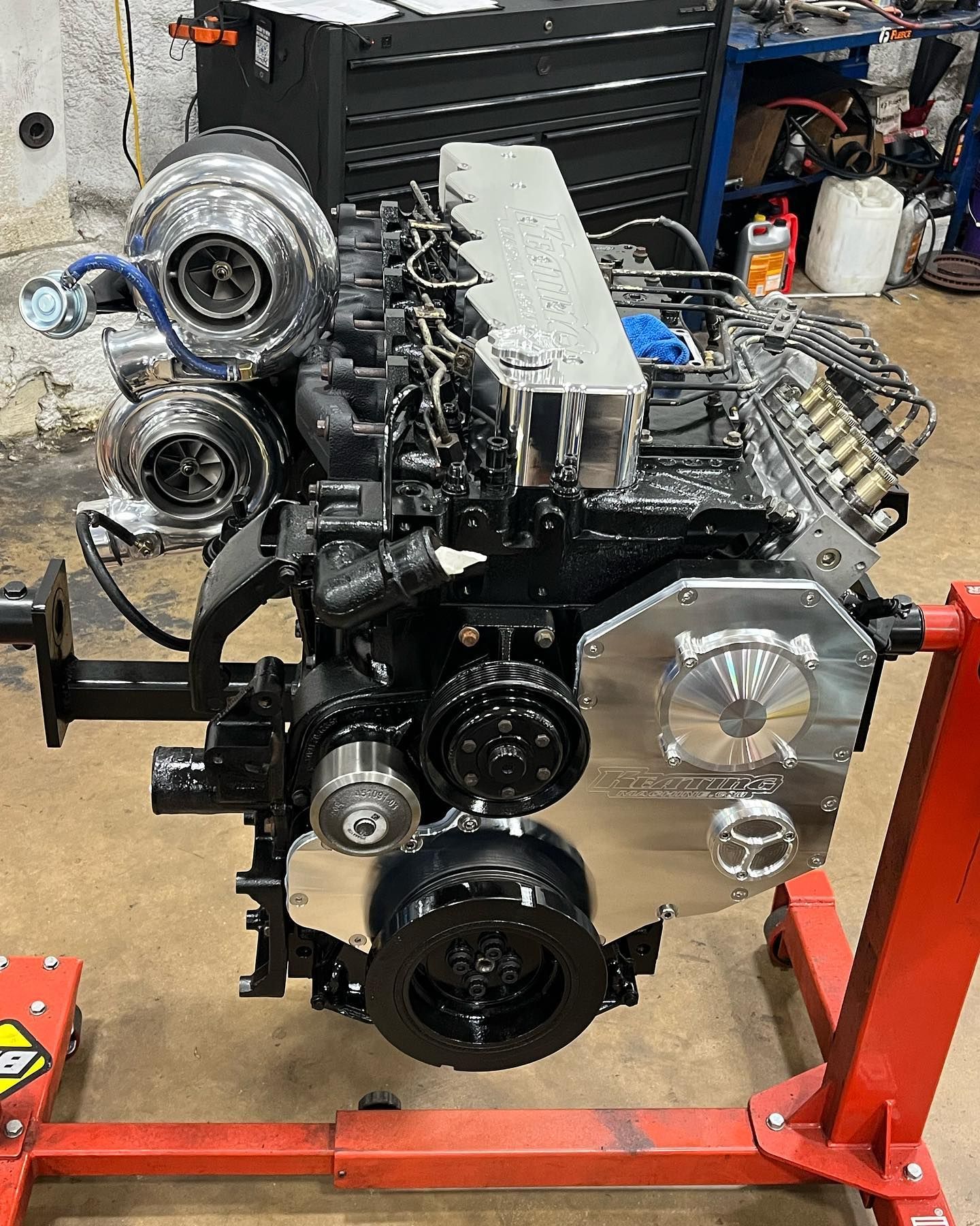 Partially assembled car engine on a red stand in a workshop