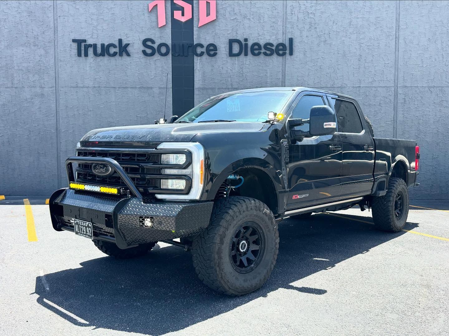 Black lifted pickup truck parked outside Truck Source Diesel building
