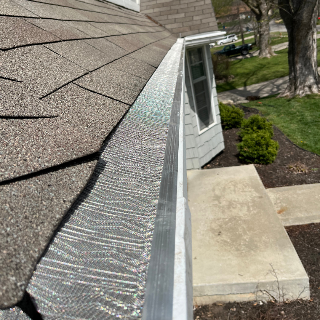A close up of a gutter on the side of a house.