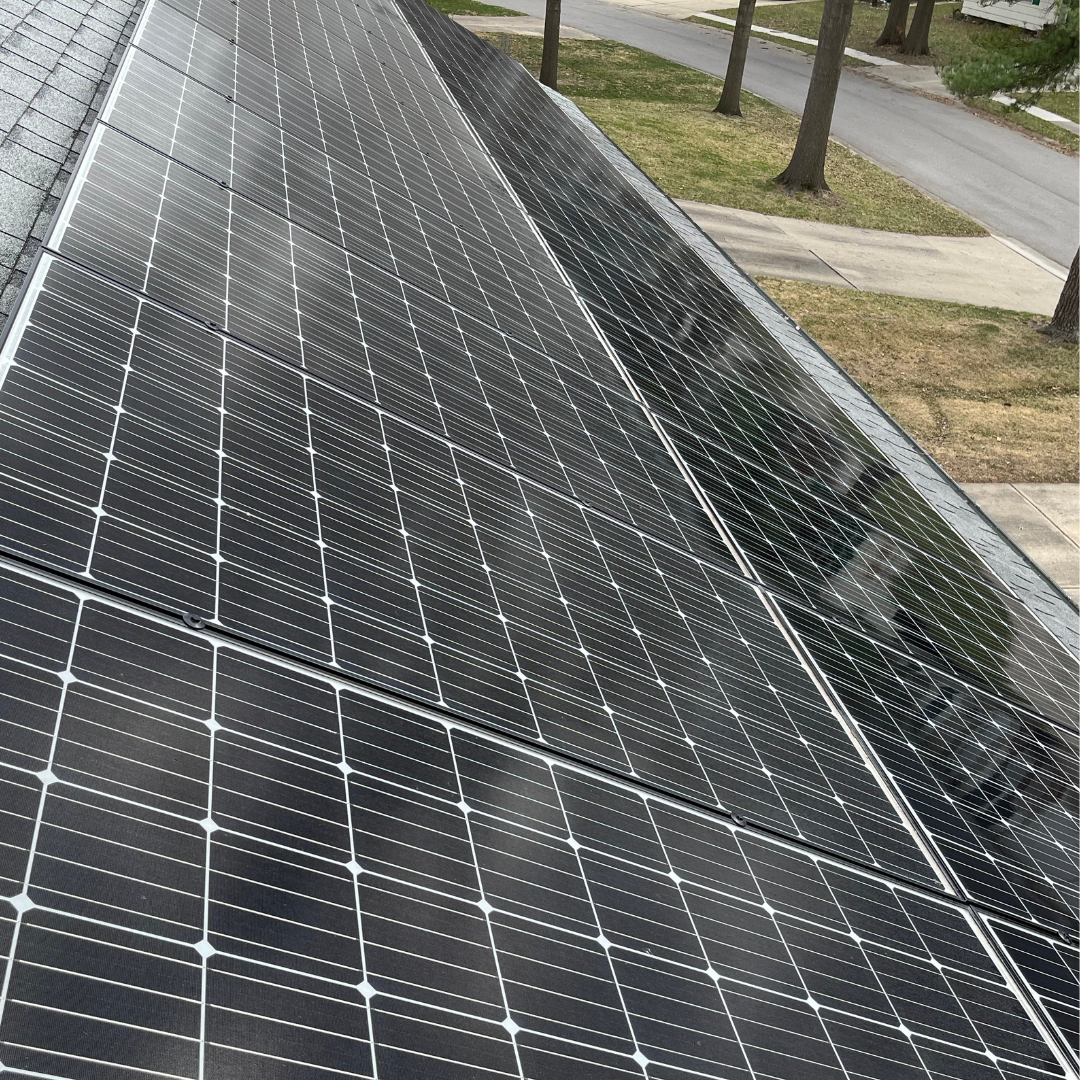 A row of solar panels on the roof of a house.