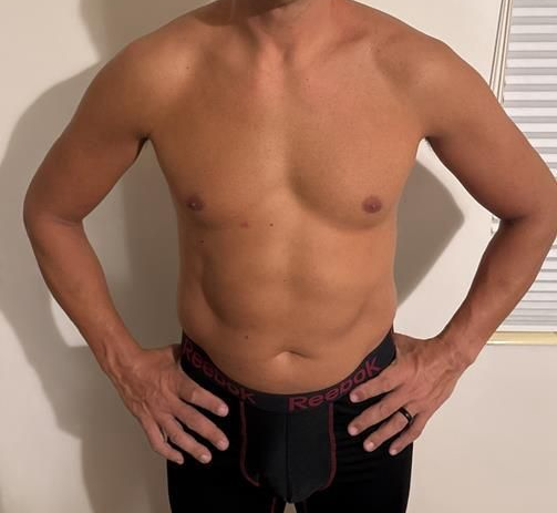 Man in black underwear, hands on hips, torso visible.