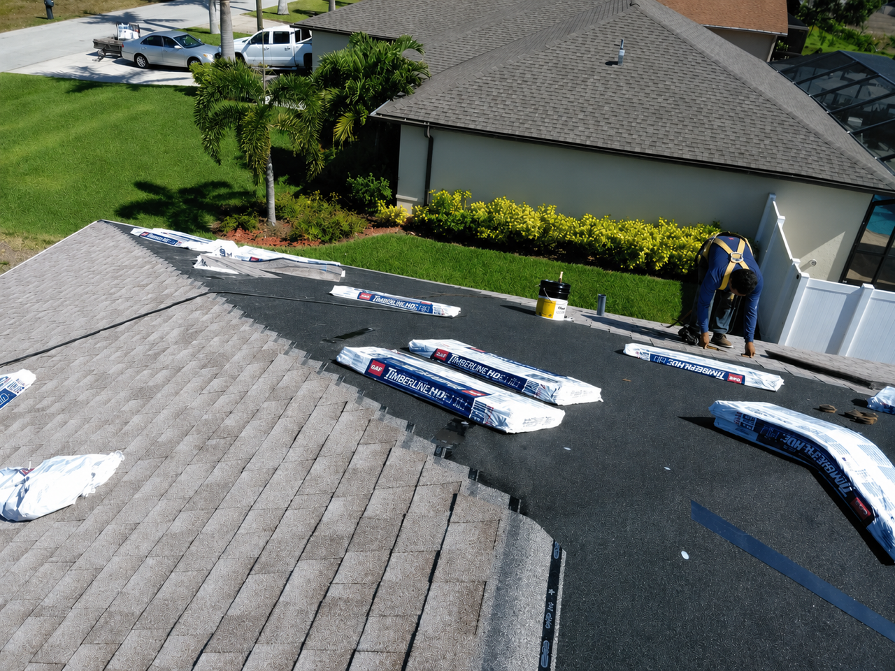 Tan house with garage and palm trees in a sunny driveway