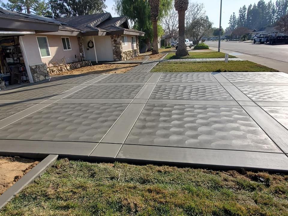 A concrete driveway is being built in front of a house.