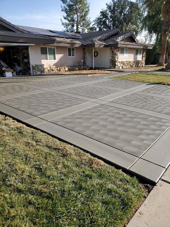 There is a concrete driveway in front of a house.