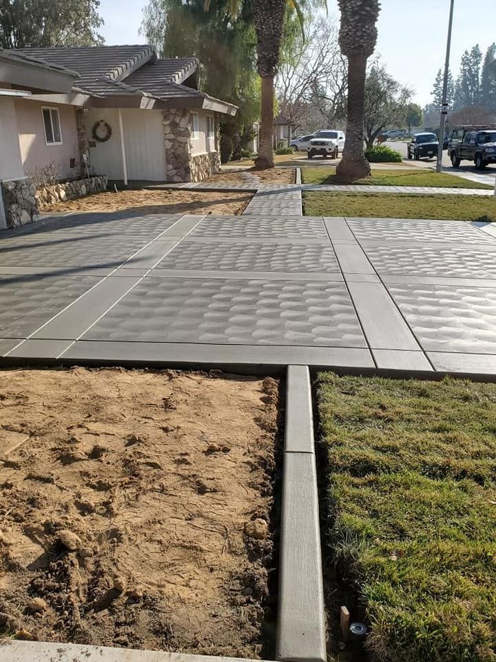 A concrete driveway is being built in front of a house
