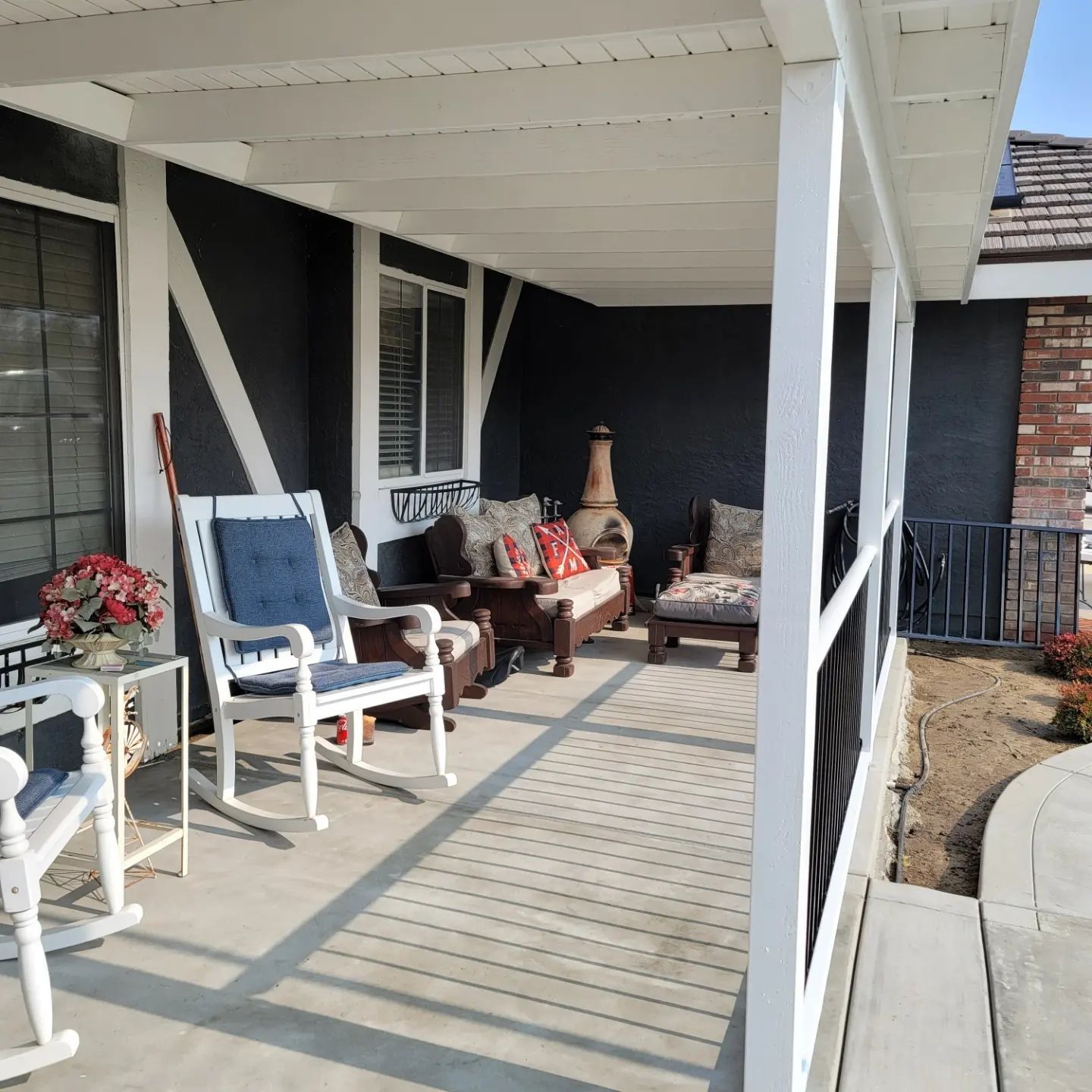 A porch with rocking chairs and a table
