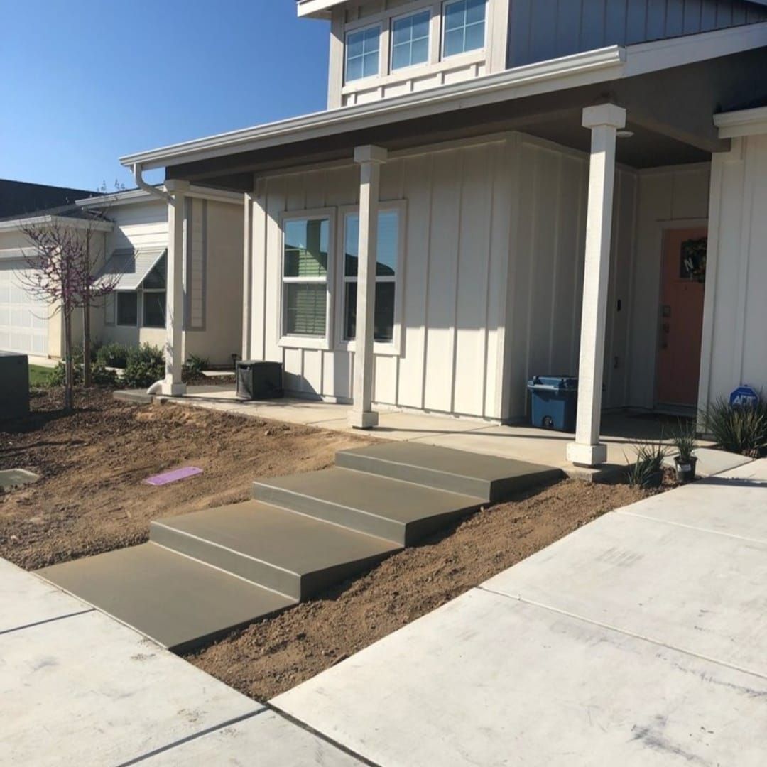 A white house with concrete steps leading up to it