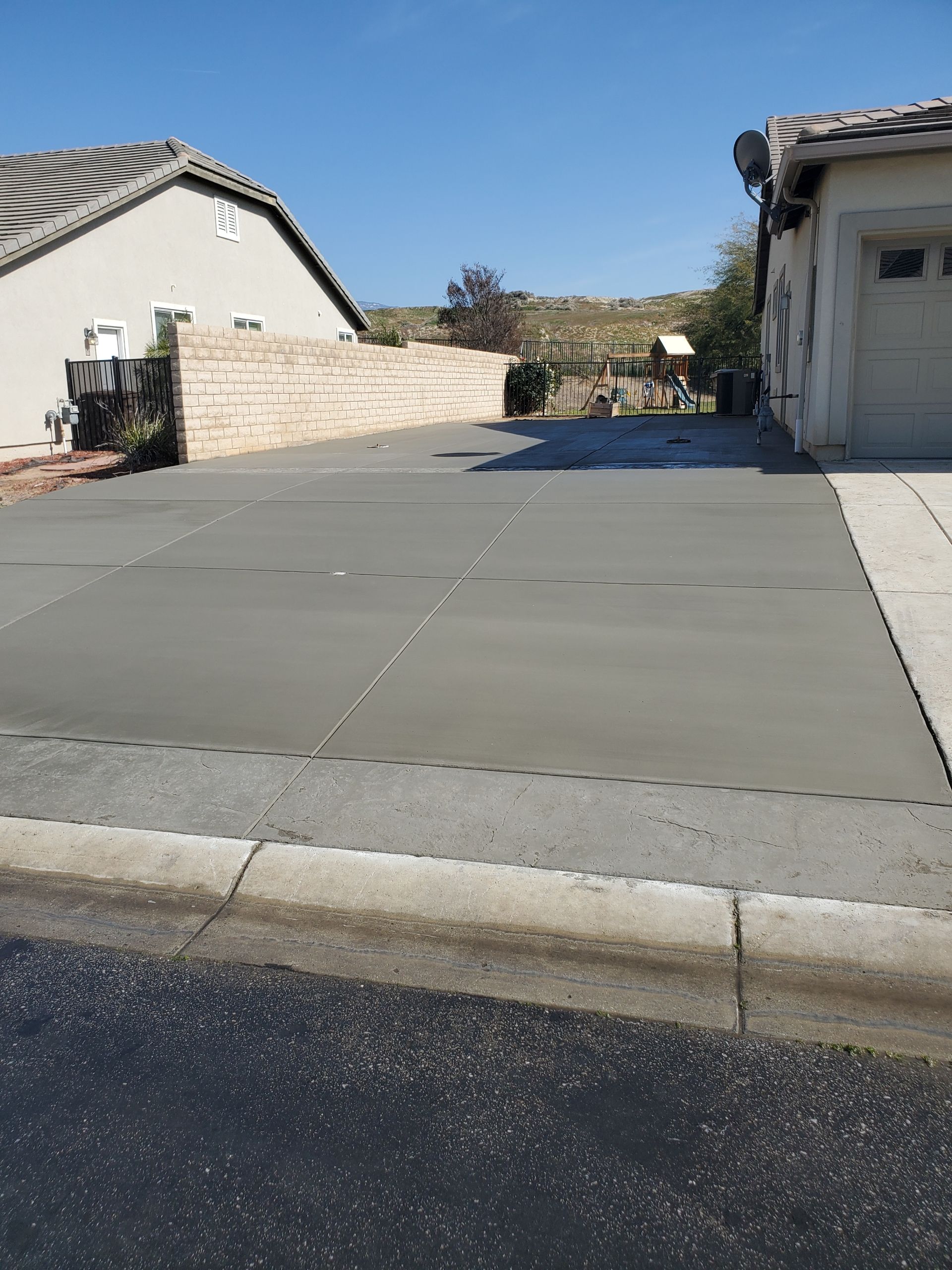 A concrete driveway is being built in front of a house.