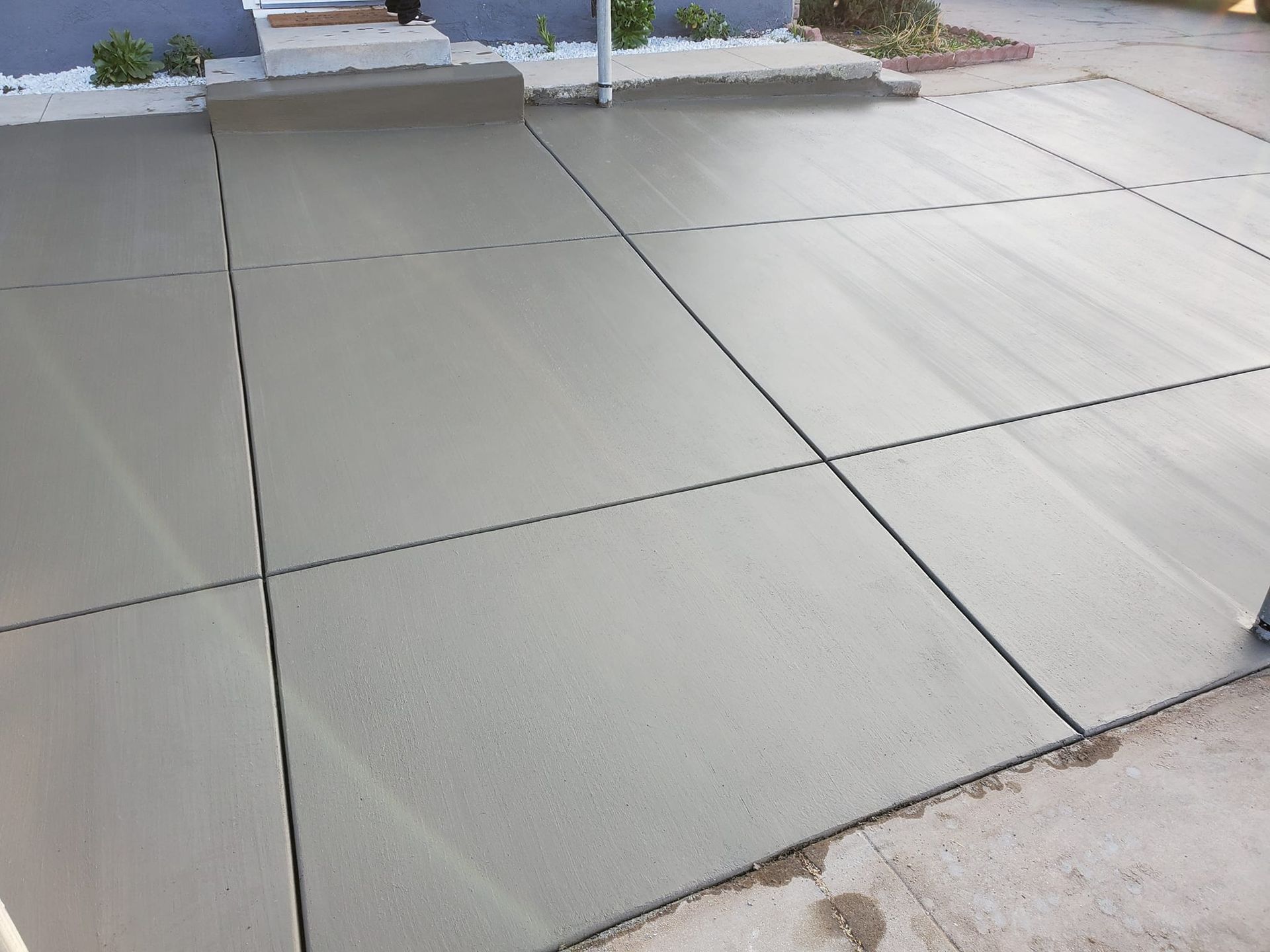 A concrete driveway is being built in front of a house.