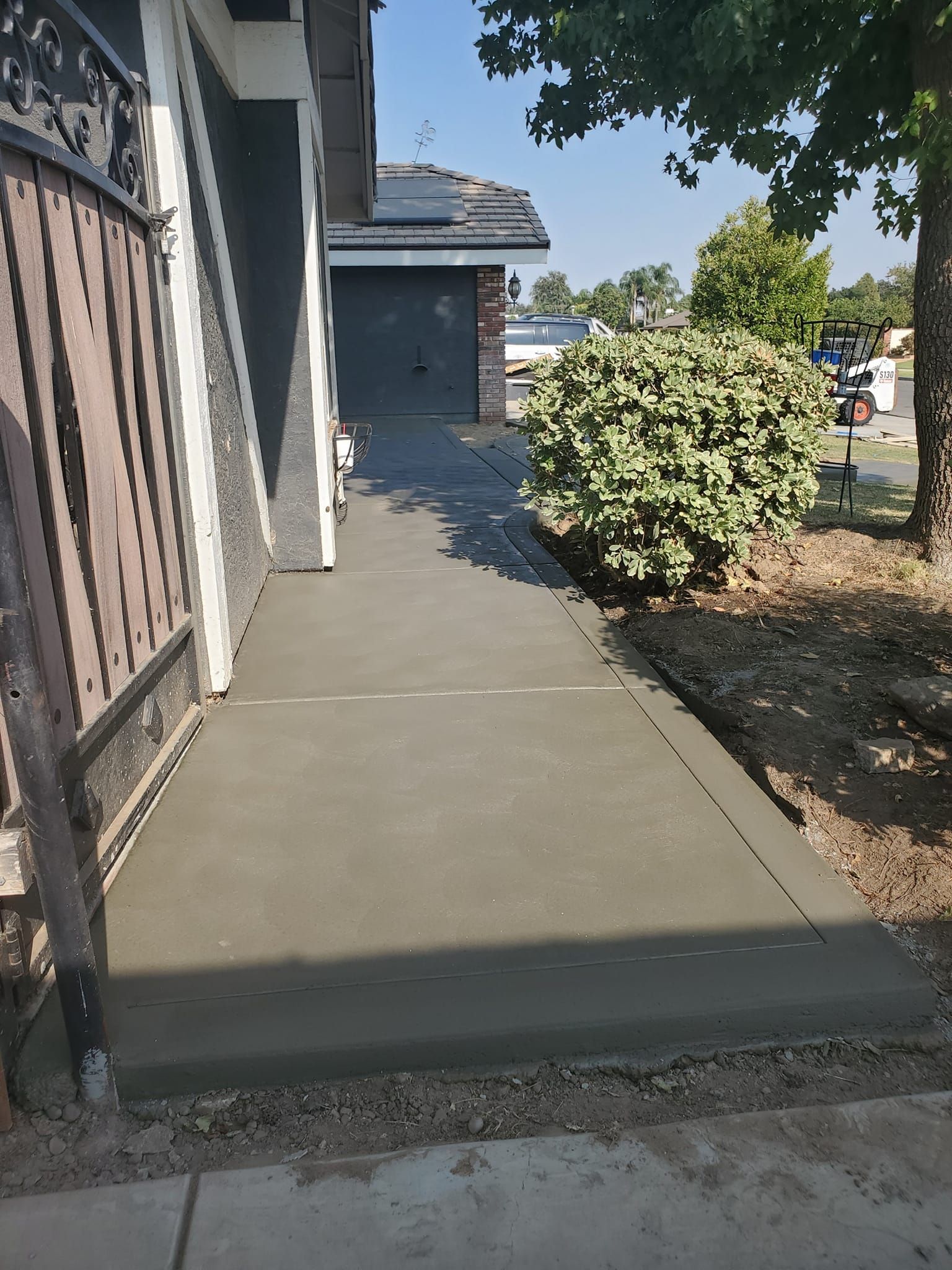 A concrete walkway is being built in front of a house.
