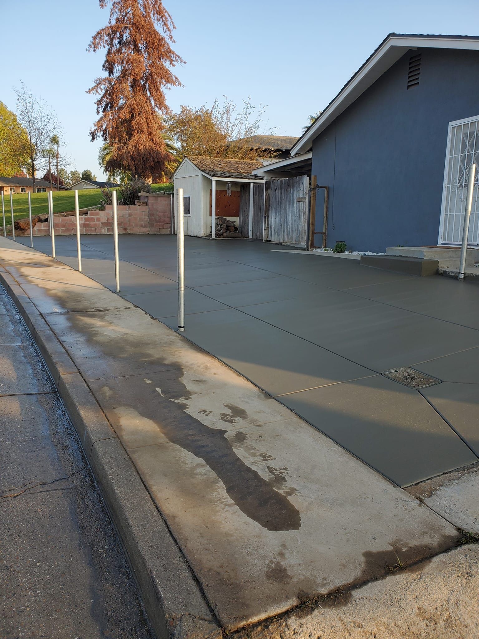 A concrete driveway is being built in front of a house