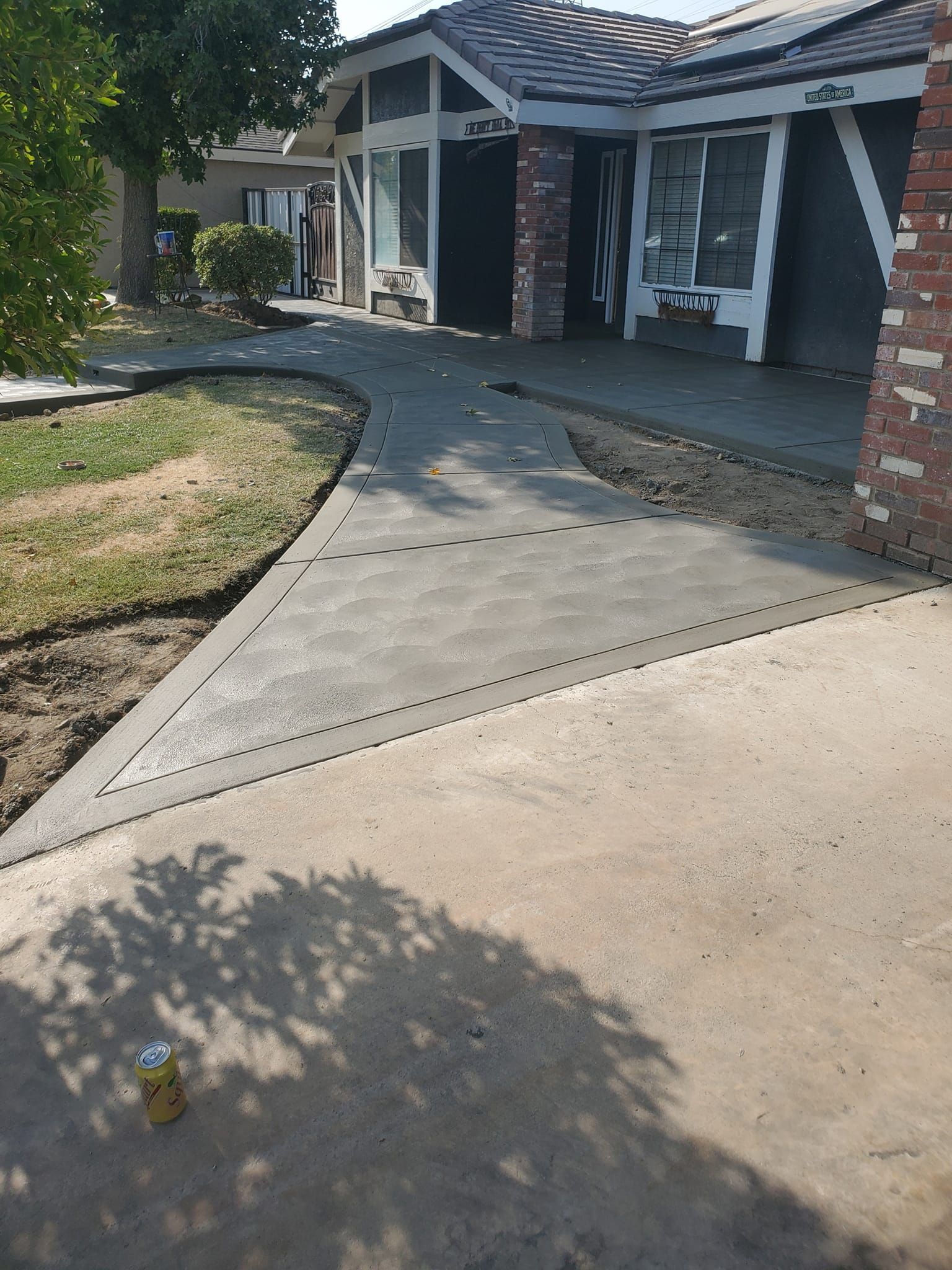 A concrete walkway is being built in front of a house.