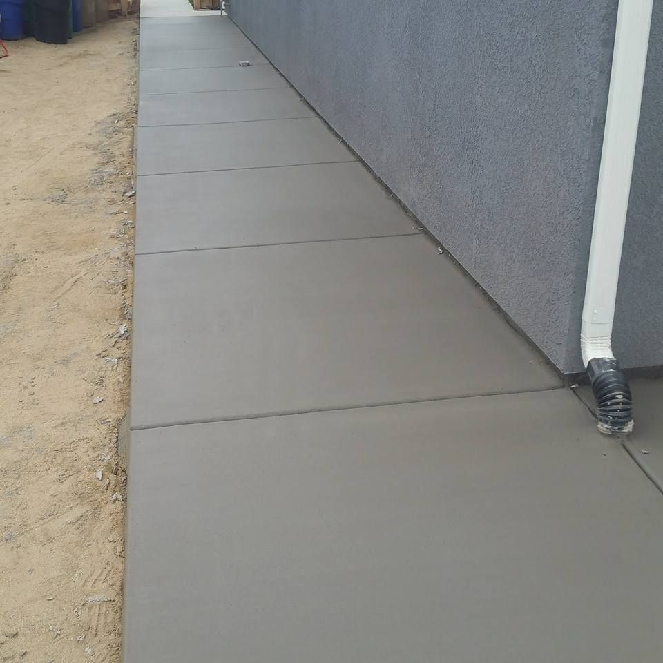 A sidewalk is being built next to a building.