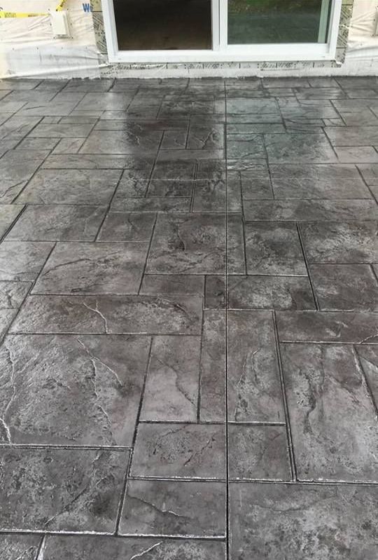 A concrete patio with a sliding glass door in the background.