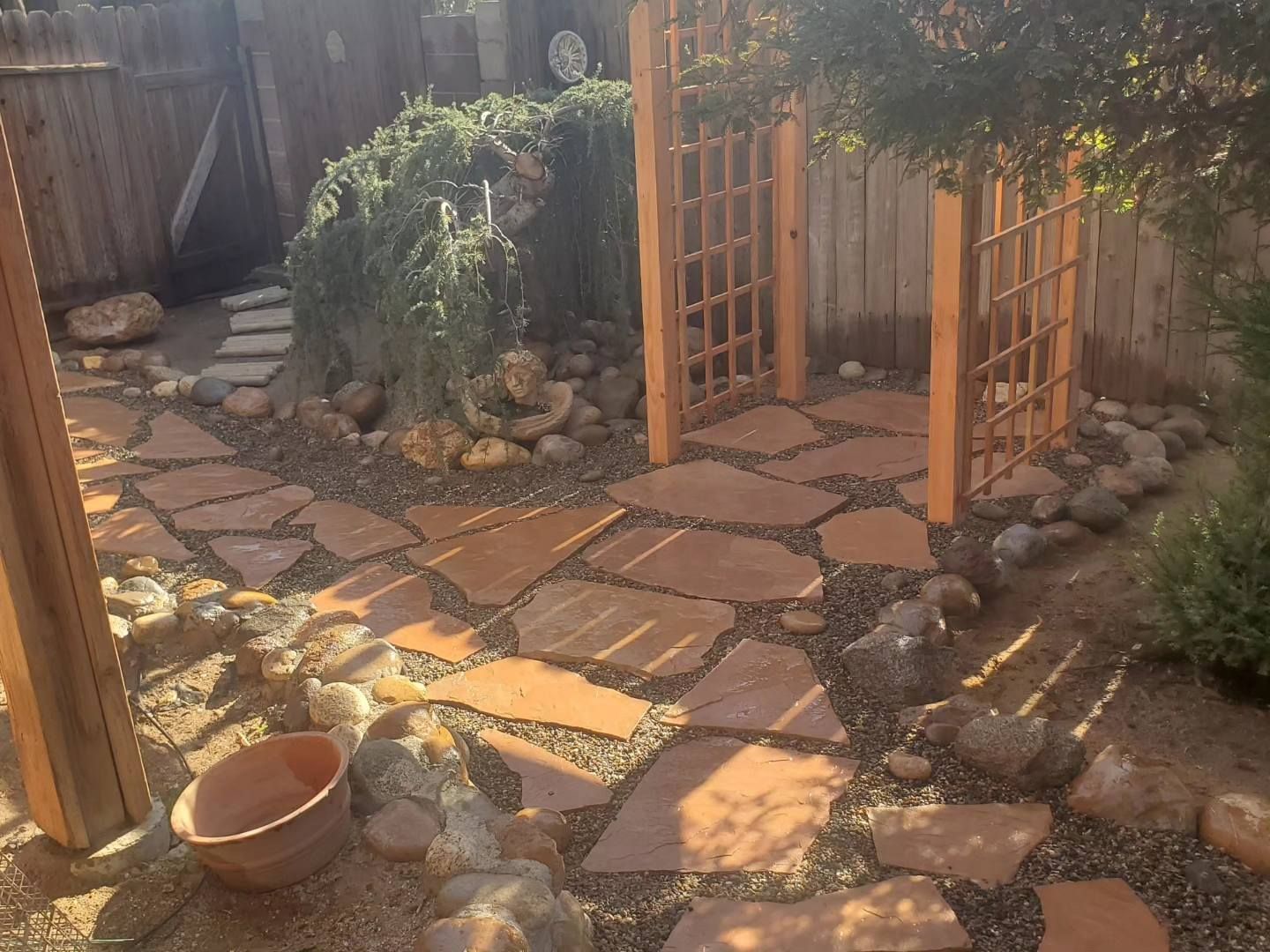 A stone walkway with a wooden fence in the background