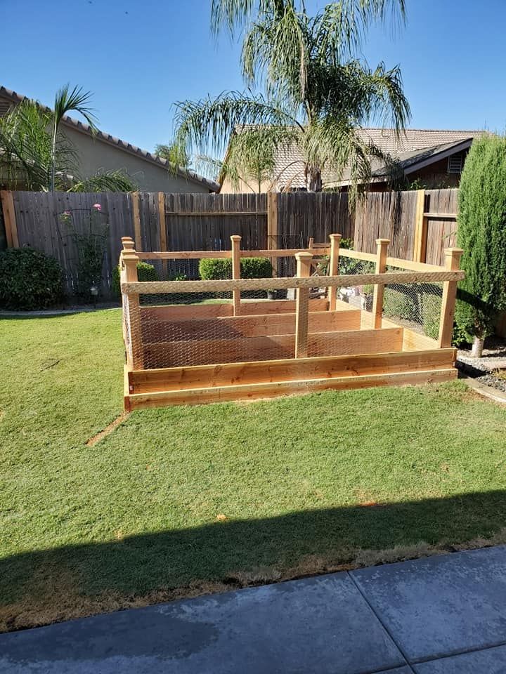 A wooden deck is sitting on top of a lush green lawn in a backyard.