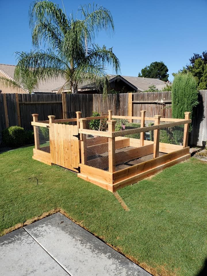 A wooden structure is sitting on top of a lush green lawn in a backyard.