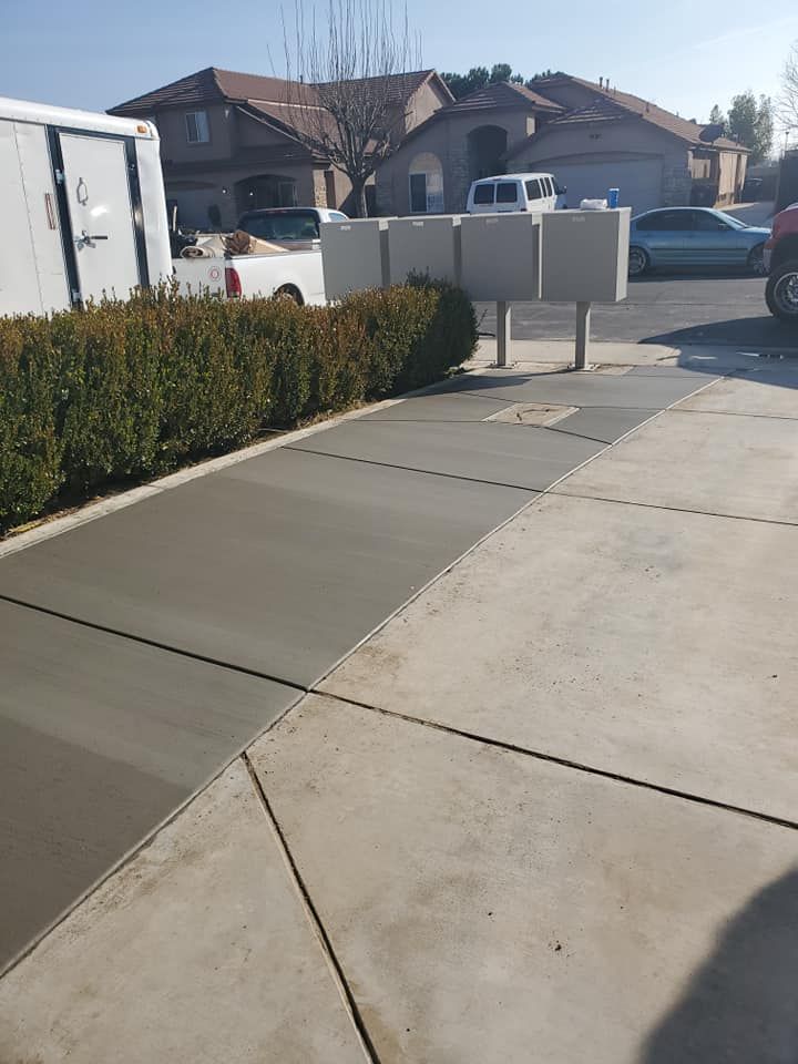 A concrete sidewalk with a truck parked on the side of it.