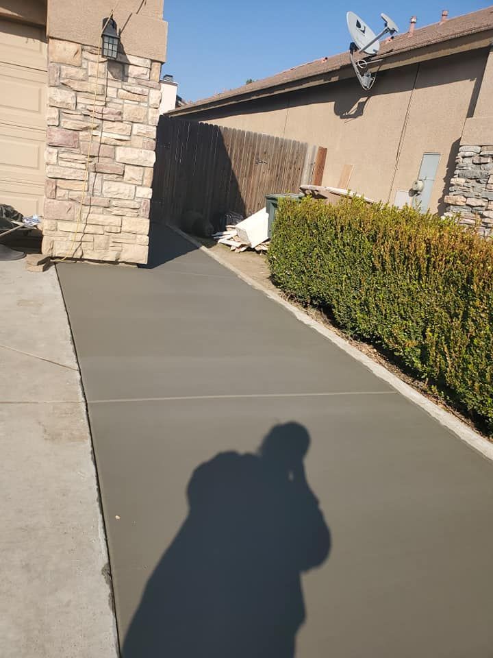 A shadow of a person is cast on a concrete walkway.